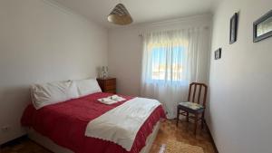 a bedroom with a red and white bed and a window at Sunset Hideaway Santa Cruz in Silveira