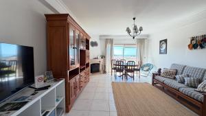 a living room with a couch and a television at Sunset Hideaway Santa Cruz in Silveira