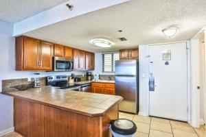 a kitchen with wooden cabinets and a stainless steel refrigerator at SunDestin Resort Unit 0615 in Destin
