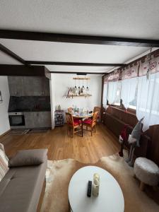 a living room with a table and a couch at Studio, proche des pistes et des commerces in Vionnaz