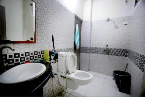 a white bathroom with a toilet and a sink at Tajiva Stay in Agra +12 photos