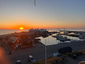 a sunset over a harbor with a marina with boats at carlsens hotel in Vesterø Havn