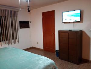 a bedroom with a bed and a flat screen tv at Casa en altos colonia lomas SLP in San Luis Potosí