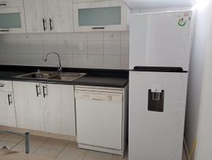 a kitchen with a white refrigerator and a sink at Casa en altos colonia lomas SLP in San Luis Potosí