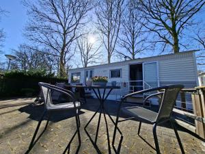 a table and chairs in front of a trailer at Gezellige, knusse, Stacaravan Banjer in Schoonloo