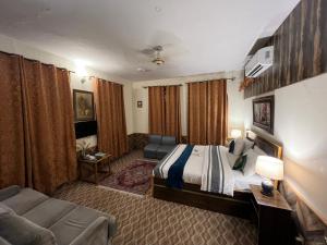 a hotel room with a bed and a couch at Duroyo hotel in Gilgit