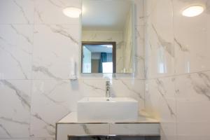a white bathroom with a sink and a mirror at ASD Hotel in Filderstadt +19 photos