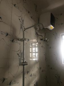 a lamp in a bathroom with a marble wall at The 7th Haven in Uyo