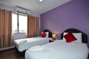 a hotel room with two beds with red and white pillows at โรงแรมสตูลธานี satun tanee hotel in Satun