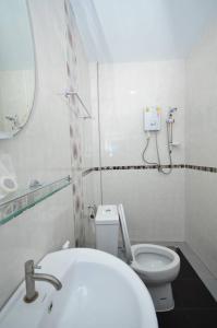 a white bathroom with a toilet and a sink at โรงแรมสตูลธานี satun tanee hotel in Satun