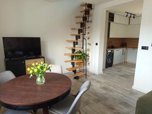 a living room with a table and a kitchen at Miła Przystań in Debrzno +6 photos