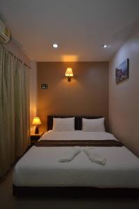 a bedroom with a large bed with two lamps on it at โรงแรมสตูลธานี satun tanee hotel in Satun +5 photos