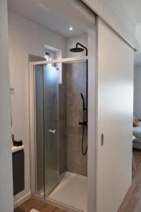a shower with a glass door in a bathroom at Orient Herent - Boetiekhotel in Herent