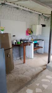 a kitchen with a table and a refrigerator at Cabaña El Tucan in Minca