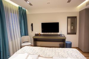a bedroom with a bed and a desk with a television at ASD Hotel in Filderstadt