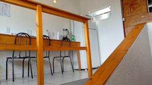 a kitchen with a wooden counter with stools at Hostel Mar in São Luís +40 photos