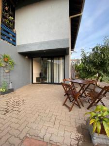 a patio with two wooden chairs and a table at Refúgio Subterrâneo in Genuino Sampaio