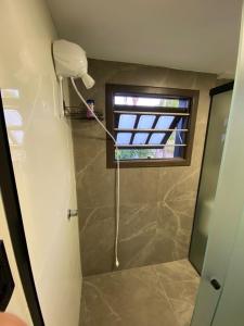 a shower in a bathroom with a window at Refúgio Subterrâneo in Genuino Sampaio +53 photos
