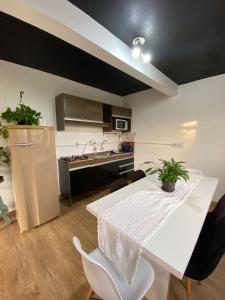 a kitchen and dining room with a white table and chairs at Refúgio Subterrâneo in Genuino Sampaio