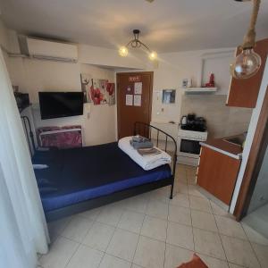 a small bedroom with a blue bed and a kitchen at Konstantinos's Luxury Studio in Thessaloniki