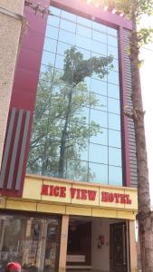 a nice view hotel with a tree reflection in a building at Nice View Hotel in Gopālganj