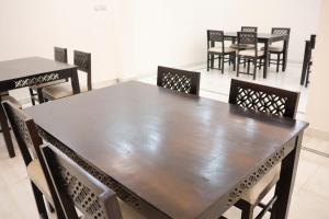a wooden table and chairs in a room at Nice View Hotel in Gopālganj