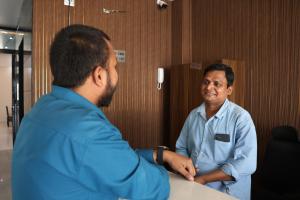 a man shaking hands with another man at a table at Nice View Hotel in Gopālganj