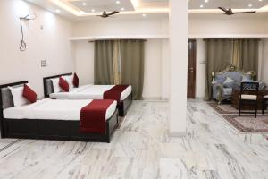 a hotel room with two beds and a chair at Nice View Hotel in Gopālganj +38 photos