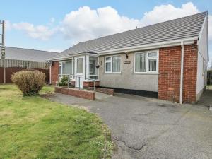 a red brick house with a driveway at Min Y Cae in Cemaes Bay