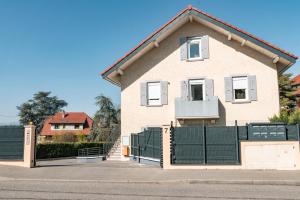 a house with a green fence in front of it at Superbe appartement proche de stations de ski in Thonon-les-Bains