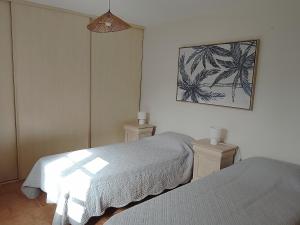 a bedroom with two beds and a picture on the wall at La Maison du Bonheur in Jaujac