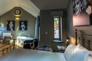 a bedroom with a bed and a bathroom with a tub at NoTwenty9 Bar and Restaurant in Burnham Market