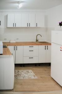 a kitchen with white cabinets and a sink at Luna Studio in Hunedoara