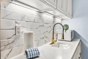 a bathroom with white marble walls and a sink at Grand Sandestin 2210 in Destin