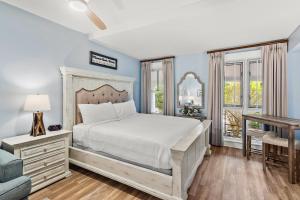 a bedroom with a bed and a desk and windows at Grand Sandestin 2210 in Destin +37 photos