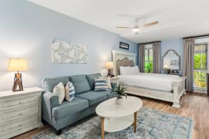 a living room with a blue couch and a bed at Grand Sandestin 2210 in Destin