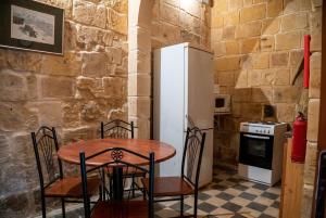 a kitchen with a table and a refrigerator at Senglea Charming 2BDR Townhouse in Senglea