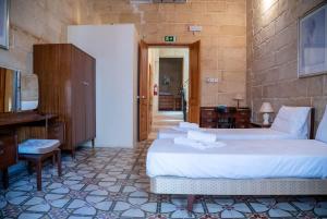a hotel room with two beds and a desk at Senglea Charming 2BDR Townhouse in Senglea