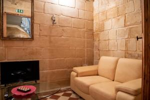 a living room with a couch and a tv at Senglea Charming 2BDR Townhouse in Senglea +12 photos