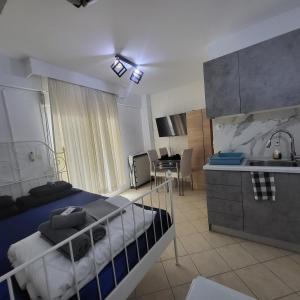 a bedroom with a bed and a kitchen with a sink at Konstantinos's Luxury Studio in Thessaloniki