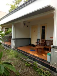 a porch of a house with chairs and a table at 4R Bungalow in Gili Islands