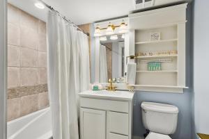 a bathroom with a toilet and a sink and a tub at Grand Sandestin 2210 in Destin