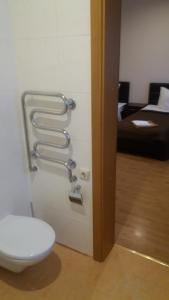 a bathroom with a toilet and a room with a bed at Vidų Guest House in Utena +62 photos