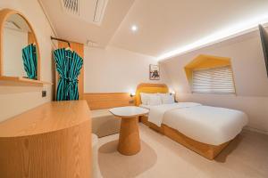 a bedroom with a bed and a table in it at 신림 빌라드보니 villa de boni in Seoul