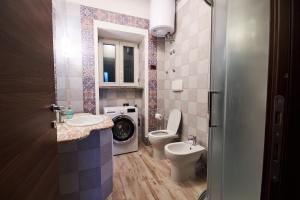 a bathroom with a toilet sink and a washing machine at San Vito Charme Apartment in Forio d'Ischia +32 photos