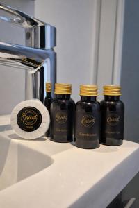 three bottles of syrup sitting on a counter next to a coffee maker at Orient Herent - Boetiekhotel in Herent +6 photos