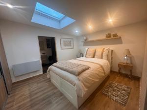 a bedroom with a large bed with a skylight at Eaunes au Soleil in Eaunes