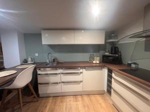 a kitchen with white cabinets and a table in it at Eaunes au Soleil in Eaunes