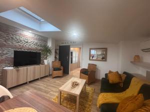 a living room with a couch and a tv at Eaunes au Soleil in Eaunes