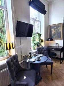 a living room with a table and chairs and a tv at Midcoast Wohnung „THE BLACK“ in Nortorf